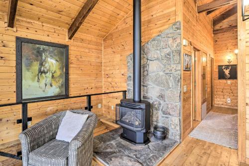 un soggiorno con camino in pietra in una baita di tronchi di Luxe Pagosa Springs Cabin with Sauna and Hot Tub! a Pagosa Springs
