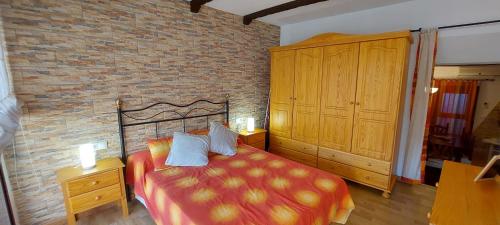 1 dormitorio con cama y pared de ladrillo en La casita de Benatae El Conserje, en Benatae