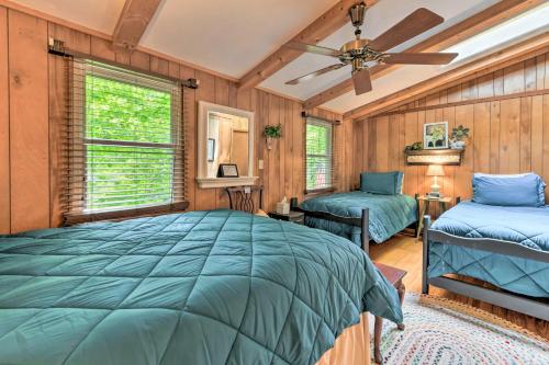 a bedroom with a large bed and a ceiling fan at Tranquil Creekside Cottage with Deck and Lanai in Franklin