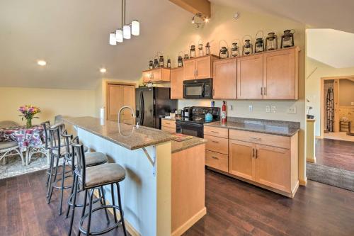 a kitchen with wooden cabinets and a island with bar stools at Duluth Studio with Sauna on Working Horse Farm! in Duluth