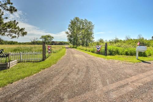 a dirt road with a fence next to a field at Duluth Studio with Sauna on Working Horse Farm! in Duluth