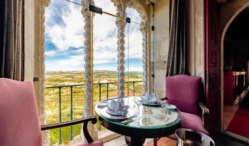 a table and chairs on a balcony with a view at Pousada Castelo de Obidos in Óbidos