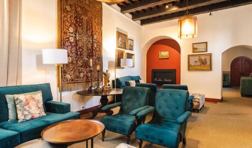 a living room with blue chairs and a table at Pousada Castelo de Obidos in Óbidos