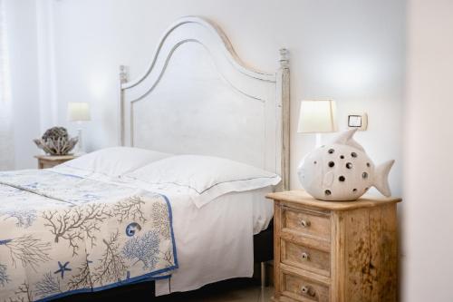 a bedroom with a bed and a table with a vase on it at Love & Fama Hotel in Sabaudia