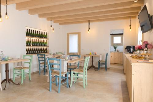 un comedor con mesas, sillas y botellas de vino en Casa Vettor, en Valdobbiadene