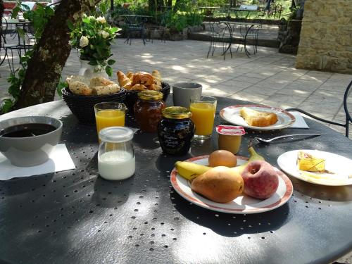 a table with plates of food and drinks on it at Hôtel Mas de l'Espaïre in Les Vans