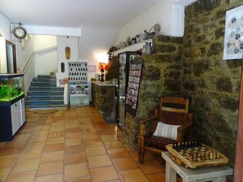 a room with a stone wall with a chess board on the floor at Hôtel Mas de l'Espaïre in Les Vans