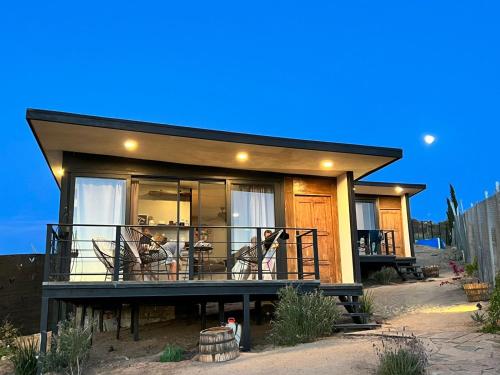 a house with a balcony with people sitting on it at Finca Cazosa in Valle de Guadalupe