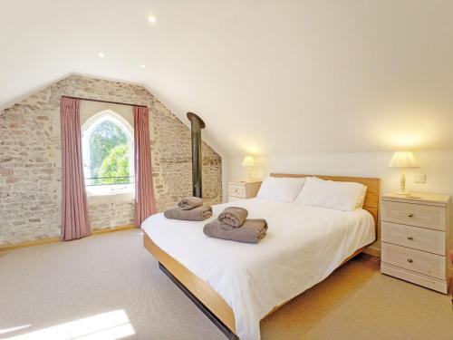 a bedroom with a large bed with towels on it at Hearnesbrook Barn , Emsworth in Emsworth