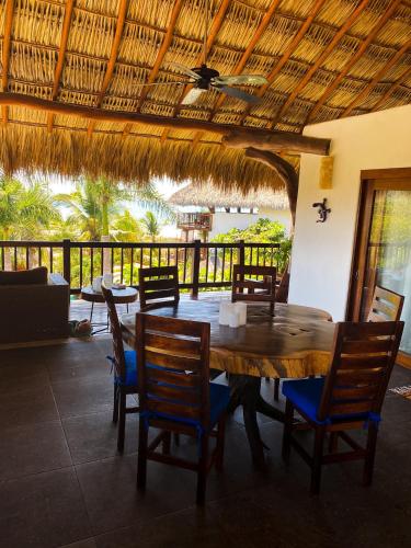 a dining room with a wooden table and chairs at Hotel Bajito Bay in Troncones