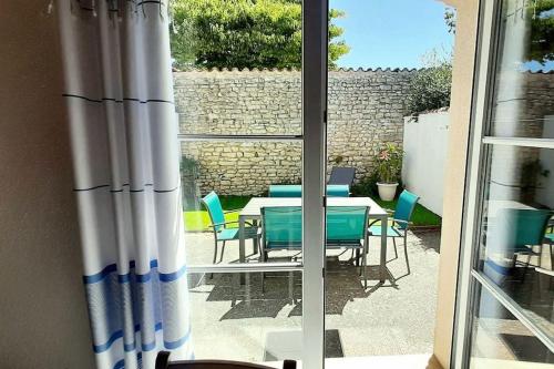 Elle offre une vue sur une terrasse avec une table et des chaises. dans l'établissement Délicieux moment de détente au coeur de Saint Martin de Ré, à Saint-Martin-de-Ré
