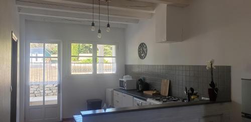 a kitchen with a stove and a microwave at Gîte du Tilleul 6 pers - Au Clos de Parranquet in Parranquet