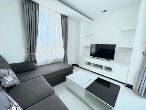 een woonkamer met een bank en een tv bij PTH Residence in Phnom Penh