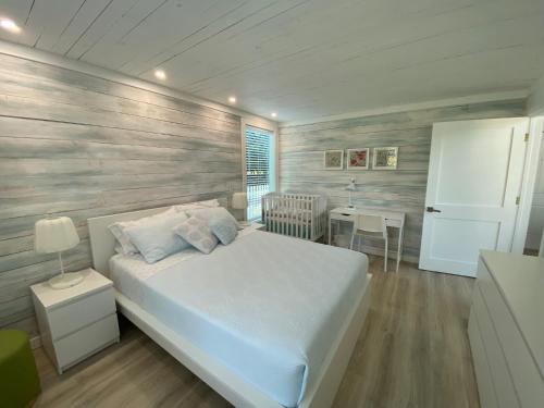 a bedroom with a white bed and a table at Maria's Los Cirhuelos in Homestead