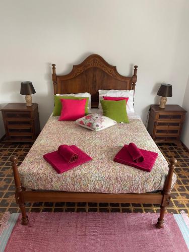 a bed with two red towels on top of it at Monte de Stª Margarida in Montemor-o-Novo