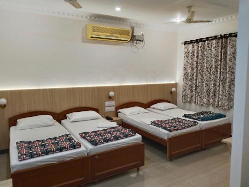 Postel nebo postele na pokoji v ubytování Hotel Nachiappa Palace