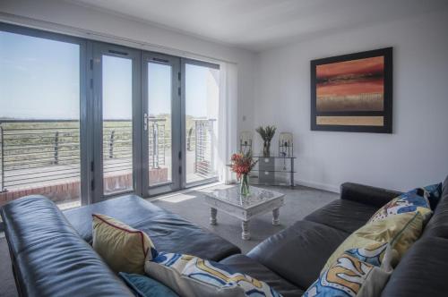 a living room with a couch and a table at Maritime Quarter - 2 Bedroom Apartment - SA1 Beach Front Fishermans Way in Swansea