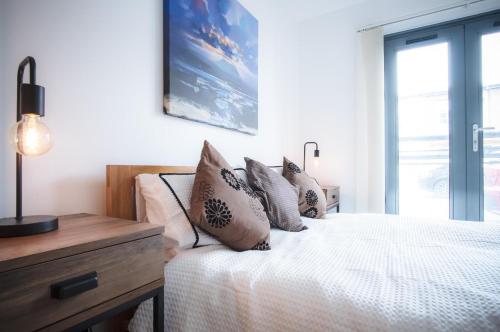 a bedroom with a bed with pillows on it at Maritime Quarter - 2 Bedroom Apartment - SA1 Beach Front Fishermans Way in Swansea