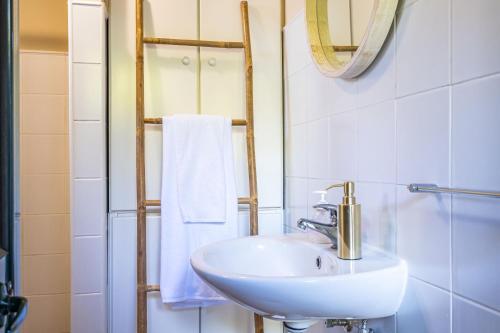 a white bathroom with a sink and a mirror at Rainbow Cottage by Madeira Sun Travel in Ponta do Pargo