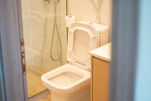 a bathroom with a white toilet and a shower at Apartment by the sea in Stalida