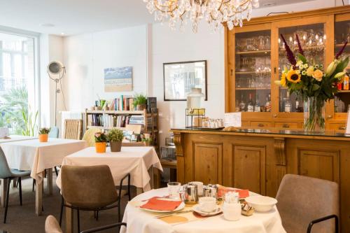 a restaurant with two tables and chairs and a bar at Hotel De Hofkamers in Ostend