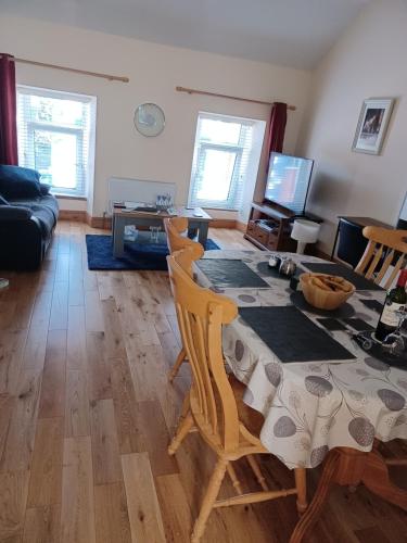 ein Wohnzimmer mit einem Tisch, Stühlen und einem Sofa in der Unterkunft Kents guesthouse accommodation in Kilmacthomas