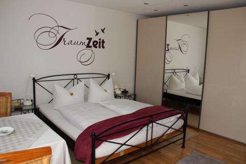 a bedroom with a bed with a sign that reads feminism at Haus Janßen-Wehrle in Titisee-Neustadt