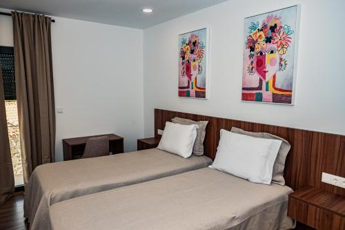 a hotel room with two beds and a window at Casas de Campo Curral Grande - By Cimo da Quinta in Pena Branca