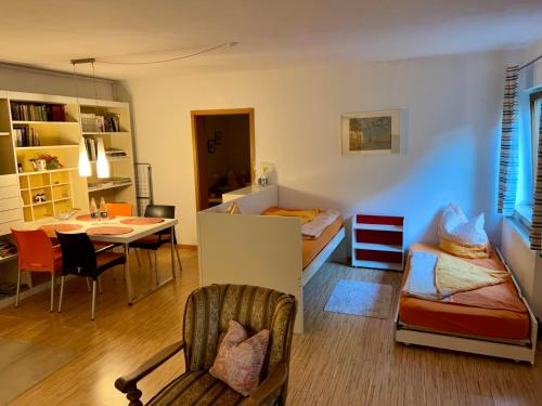 Cette chambre comprend une table, un lit et une salle à manger. dans l'établissement Appartement im Ahlesbrunnen, à Bietigheim-Bissingen
