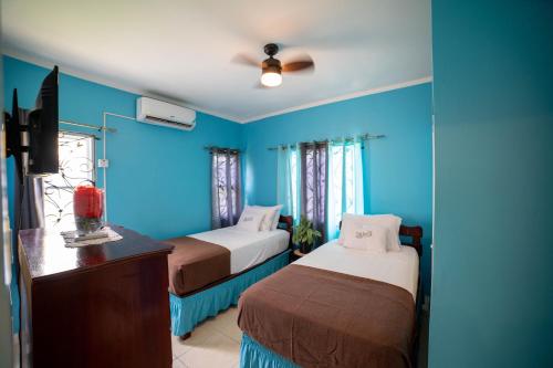 niebieski pokój z 2 łóżkami i komodą w obiekcie Nickels Garden Villas w mieście Montego Bay