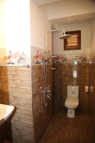 a bathroom with a shower with a toilet and a sink at Rawana Mountain View in Ella