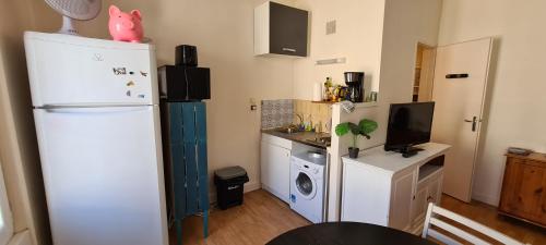 une cuisine avec un réfrigérateur et une machine à laver dans l'établissement Studio Centre Ville pratique et cosy, à La Rochelle