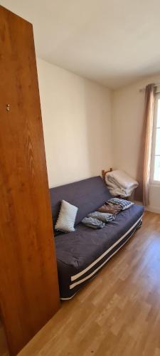 - un lit dans l'angle de la chambre dans l'établissement Studio Centre Ville pratique et cosy, à La Rochelle