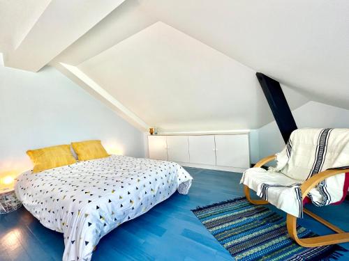 um quarto no sótão com uma cama e uma cadeira em BERNARDINE - Hyper Centre Reims Famille em Reims