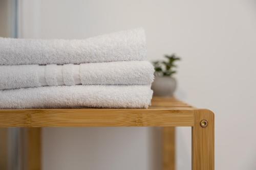 a pile of towels sitting on a wooden rack at Ko-Living - Gaming Suite am Alten Markt - Altstadt - 6P in Halle an der Saale