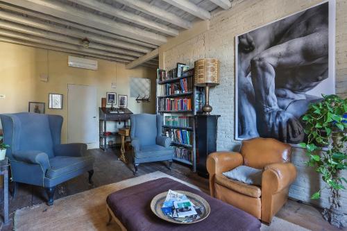 a living room with two chairs and a book shelf at La Maison at The Old Bridge in Florence