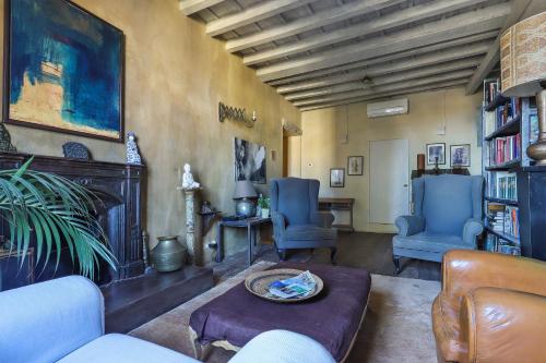 a living room with two blue chairs and a fireplace at La Maison at The Old Bridge in Florence