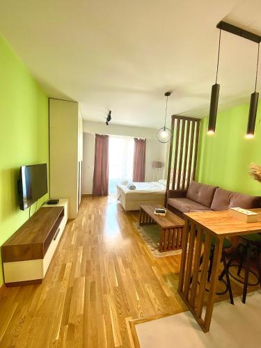 ein Wohnzimmer mit einem Sofa und einem Tisch in der Unterkunft Urban Garden APARTMENT in Skopje