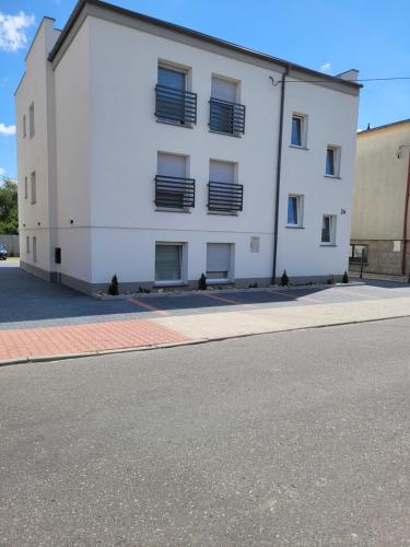 a white building on the side of a street at Paloma11 in Krotoszyn