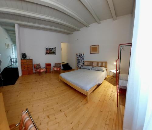 Schlafzimmer mit einem Bett und Holzboden in der Unterkunft Guiscarda Turismo in Bari