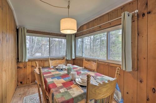 a dining room with a table and some windows at Walk to Marina Cute Gilford Cottage with Grill in Gilford