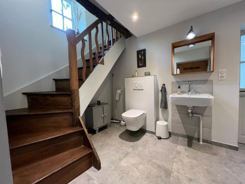 ein Badezimmer mit einem Waschbecken, einem WC und einer Treppe in der Unterkunft Le logis de Lasteyrie in La Rochebeaucourt-et-Argentine