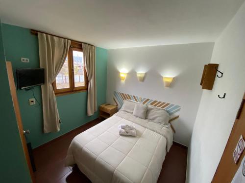 a bedroom with a bed with a stuffed animal on it at MAKTUB HOSTERIA in El Bolsón