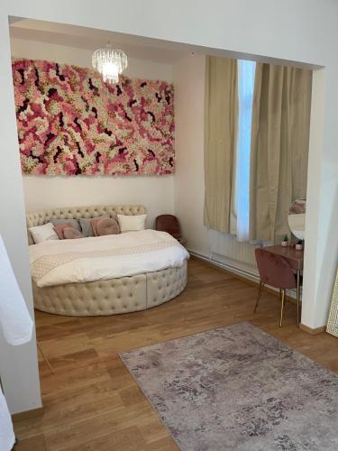 a bedroom with a bed with a flower painting on the wall at Golden Suite - JACUZZI SAUNA in Rouen