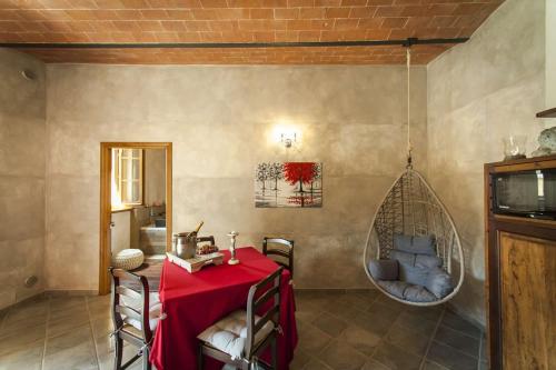 a dining room with a table and a swing at Agriturismo Belagaggio in Montefollonico