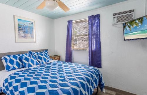 Schlafzimmer mit einem blauen und weißen Bett und einem Fenster in der Unterkunft Bungalow 1 minute from the beach Suite #3 in Englewood