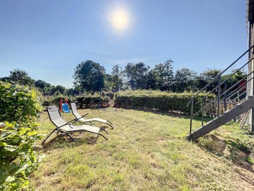 two benches sitting in the grass in a field at Sweet Moments in Hargimont