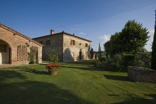 een groot bakstenen huis met een tuin met bloemen bij Agriturismo Belagaggio in Montefollonico