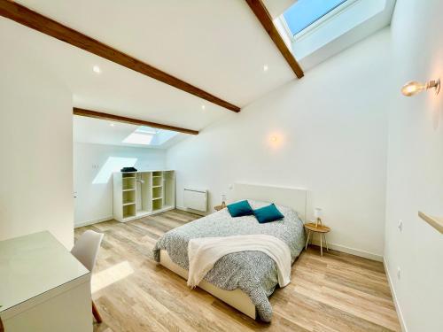 1 dormitorio con 1 cama con almohadas azules en *ARENA* - duplex lumineux, en Reims