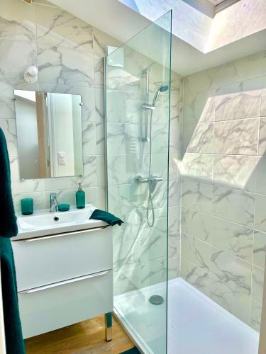 une salle de bain blanche avec une douche et un lavabo dans l'établissement *ARENA* - duplex lumineux, à Reims